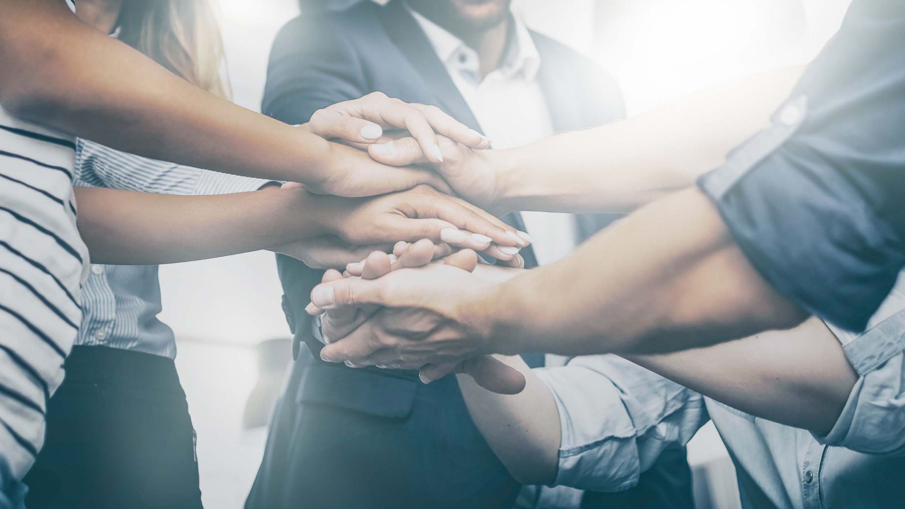 group of community members grouping their hands together